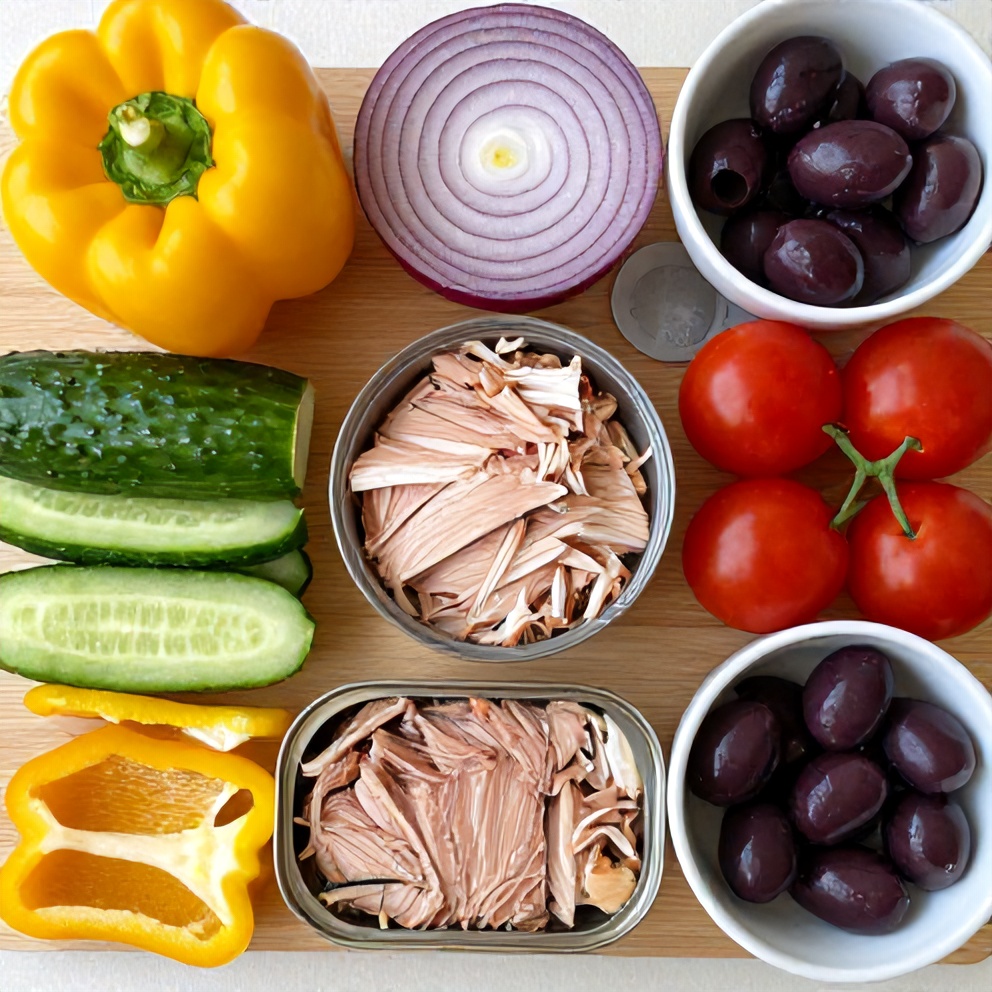 Mediterranean Tuna Salad ingredients laid out on a wooden board