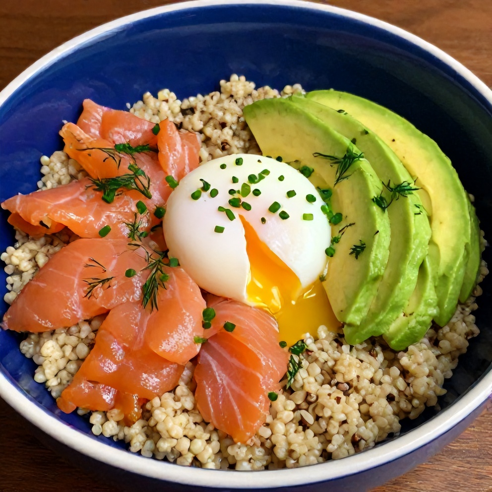 Close-up of creamy smoked salmon quinoa breakfast bowl with poached egg, avocado, and fresh herbs
