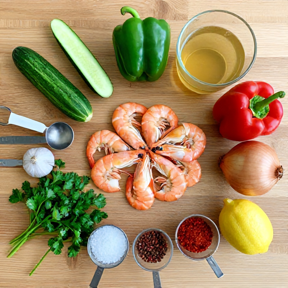 Raw ingredients for summer gazpacho with shrimp laid out on a wooden surface