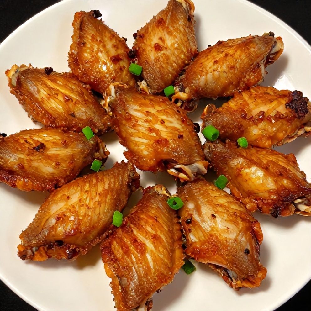 Plated Crispy Spicy Baked Chicken Wings with green onions